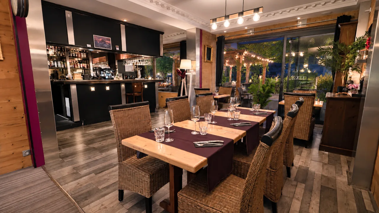 Le bar et les tables dressées, le soir, devant la baie qui donne sur la terrasse